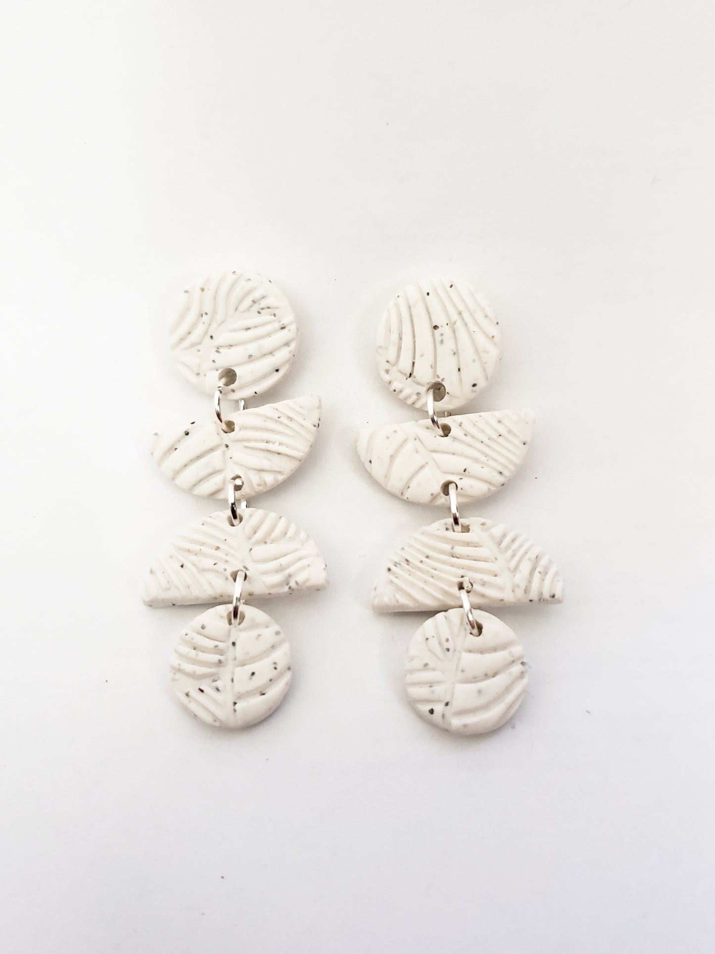 Leafy line textured stud dangles (circle, half circle, half circle, circle) in speckled white